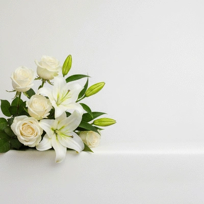 Bouquet of white roses and lilies, symbolizing purity and peace, on a clean background.